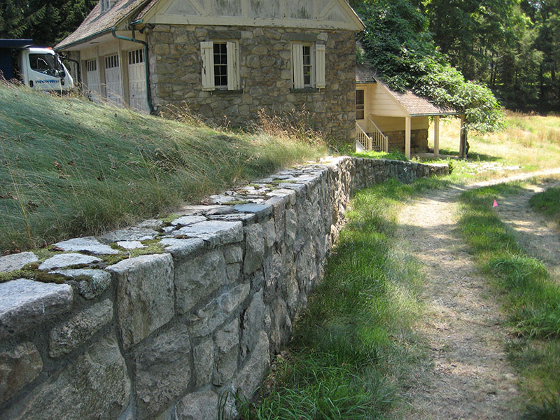 stone wall with barn in background