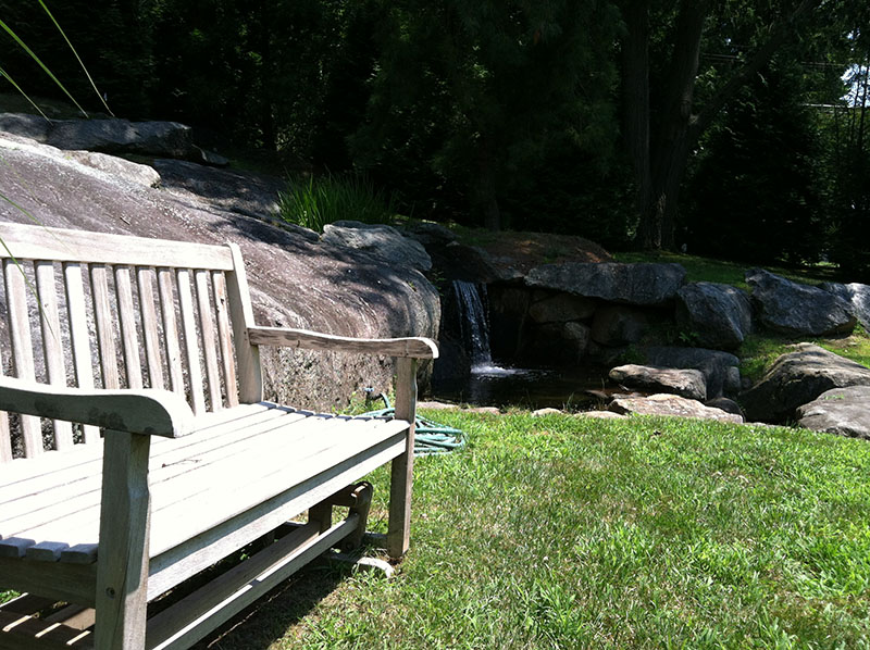 wooden bench with creek waterfall