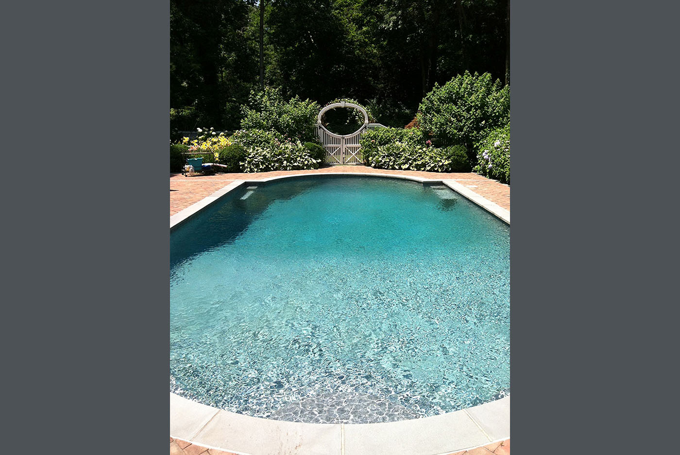 landscaping around pool with white fence