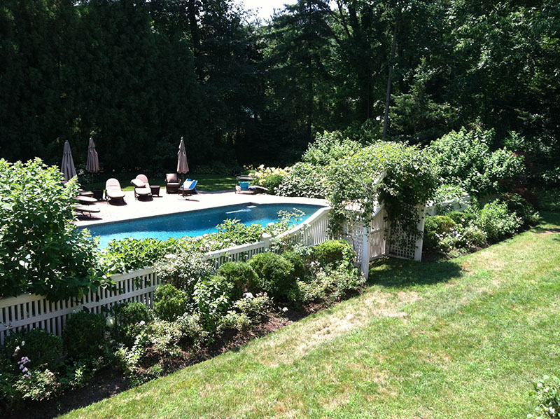landscaping around pool with white fence