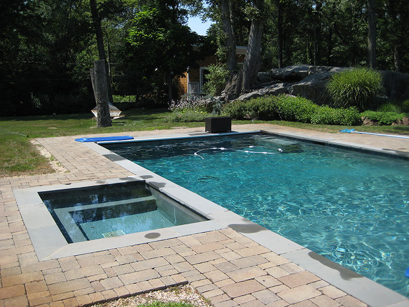 large swimming pool with stone patio